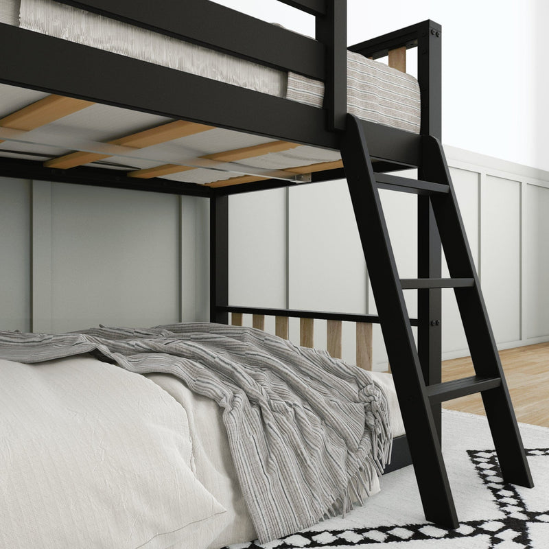 Black metal loft bed frame with ladder, wooden slats and mattress, striped gray throw over white bedding in a modern minimalist bedroom interior