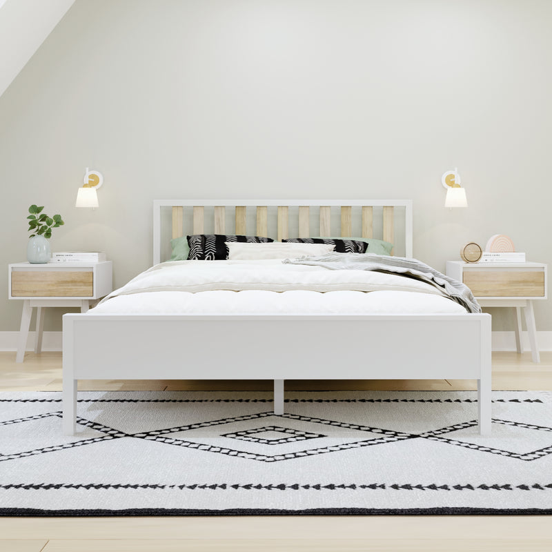 Minimalist Scandinavian bedroom with white wooden bed and slatted headboard, matching nightstands, wall sconces, green plant, bedside clock and black-and-white geometric rug