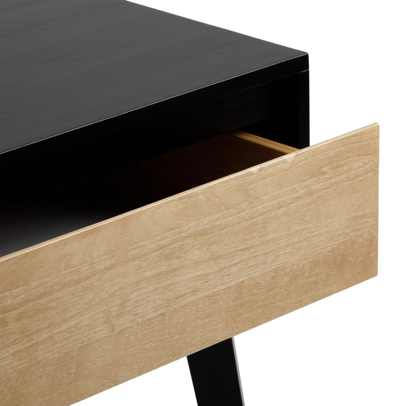 Minimalist mid-century modern desk with black top and natural wood drawer front partially open, showing interior storage space
