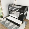 Black wooden twin bunk bed with pull-out trundle, black-and-white patterned bedding and decorative pillows in a bright modern kids' bedroom