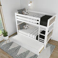Modern white wooden bunk bed with pull-out trundle, black-and-white bedding and patterned pillows in a minimalist kids' bedroom with ladder, wall sconce and potted plant