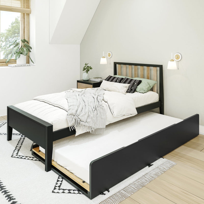 Modern minimalist bedroom with black wooden trundle bed, white cozy bedding, patterned pillows, bedside table, wall sconces and natural light