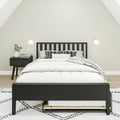 Minimalist bedroom with black wooden bed frame, white bedding, patterned pillows, nightstand with plant and wall sconces