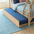 Light oak wooden trundle bunk bed with ladder in kids bedroom, navy and pastel blue bedding and blue area rug on hardwood floor