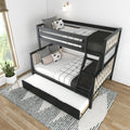 Black modern bunk bed with pull-out trundle and ladder in bright kids' bedroom with gray-and-white bedding, decorative pillows, wall sconce, potted plant and wood flooring