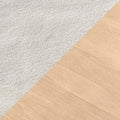 Close-up diagonal carpet-to-hardwood transition: plush white carpet to light oak hardwood flooring showing carpet texture and wood grain.