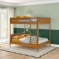 Wooden bunk bed with striped bedding and mustard yellow pillows against a two-tone green accent wall with mint wall sconces and sheer window curtains in a bright kids' bedroom