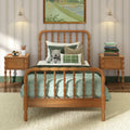 Cozy kids bedroom with wooden spindle twin bed, green quilted bedding and decorative pillows, plush teddy bear, matching wooden nightstands with pendant lamps, striped wallpaper and framed artwork