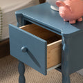 Blue bedside nightstand with open wooden drawer and pink ceramic piggy bank on top, bedroom decor