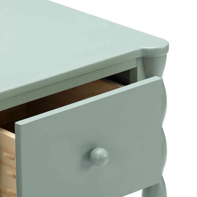 Mint green painted wooden nightstand with open drawer and round knob, scalloped edge and turned legs for bedroom storage