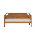 Front view of solid wood bed frame with carved headboard and woven side panels, white mattress, isolated on white background