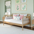 Pastel nursery with wooden daybed, pink pillows and floral framed art on mint green walls, cozy children's bedroom decor