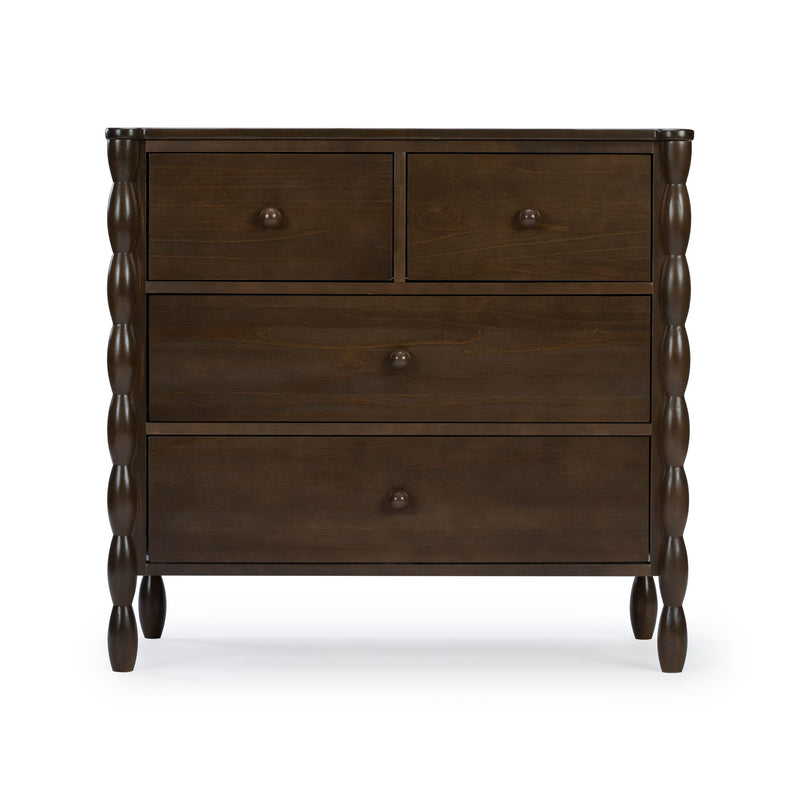Dark brown wooden dresser with four drawers, turned legs and round knob handles, close-up front view on white background