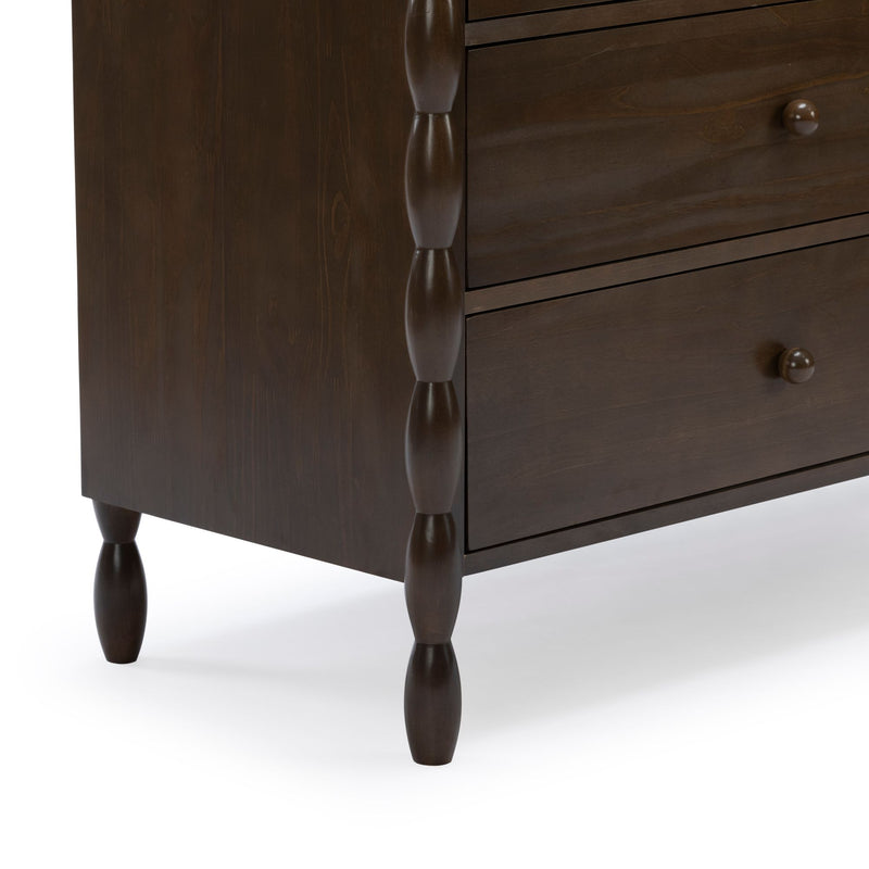 Close-up of dark brown walnut-finish wooden dresser showing spindle-style turned legs, carved vertical posts and drawer fronts with round wooden knobs