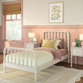 Pink nursery with white spindle bed, yellow gingham bedding, scalloped wainscoting and nightstand lamp