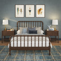 Cozy coastal bedroom with wooden spindle bed, blue-gray accent wall, three framed fishing prints above the headboard, bedside lamps, patterned blue plaid rug, decorative pillows and plush toys