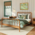 Cozy kids bedroom with wooden spindle bed, green bedding, striped wallpaper, framed art, window with roman shade and nightstand