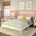 Pastel pink girls bedroom with cream spindle bed, yellow gingham bedding, scalloped wainscoting, framed floral prints, woven jute rug and Roman shade