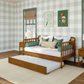Cozy children's bedroom featuring a wooden daybed with pull-out trundle, green plaid wallpaper, roman shade, tennis-themed wall art and layered pillows