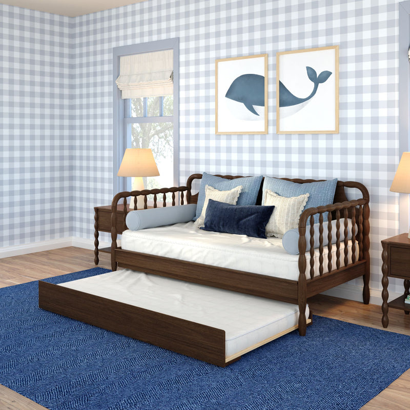 Children's coastal bedroom with light blue gingham wallpaper, wooden daybed with trundle, navy and cream pillows, whale wall art and blue area rug