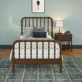 Kids bedroom with wooden spindle twin bed, blue accent wall, plush frog toy and layered navy pillows, wooden nightstand with white table lamp and alarm clock, textured blue patterned area rug