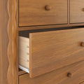 Close-up wooden dresser with partially open drawers, dovetail joints, round knobs and warm wood-grain finish for bedroom storage