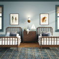 Nautical twin kids bedroom with wooden spindle beds, sailboat model, octopus plush, blue plaid rug, framed fish art and brass wall sconce