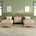 Twin wooden beds in a green children's bedroom with striped bedding, natural light, framed whale wall art, plush frog and wooden nightstand