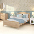 Cozy bedroom interior with light wood bed, pastel blue bedding, floral wallpaper, blue wainscoting, bedside lamps and wooden dresser