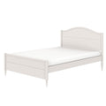 White twin wooden bed frame with arched headboard, scalloped footboard, turned legs and mattress, farmhouse-style bedroom furniture