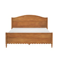 Solid wood bed frame with arched headboard, scalloped footboard and turned legs in warm honey-toned finish