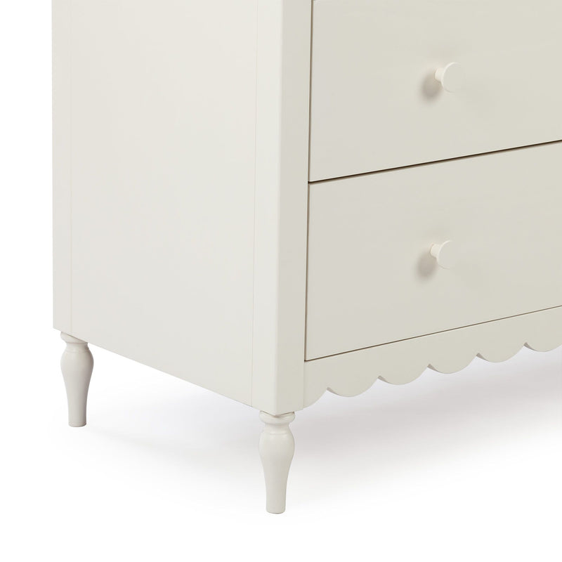 White wooden dresser nightstand with two drawers, round knob pulls, turned legs and scalloped apron for farmhouse bedroom or nursery storage
