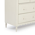 Cream white wooden dresser with drawers and round knob pulls, scalloped apron and turned legs — classic bedroom nursery storage chest