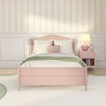 Pastel pink girls bedroom with scalloped headboard, white bedding and pillows, green throw, floral striped wallpaper and pink nightstand lamp