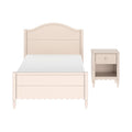 Pastel pink wooden twin bed with arched headboard and scalloped footboard beside matching nightstand – shabby chic kids' bedroom furniture set