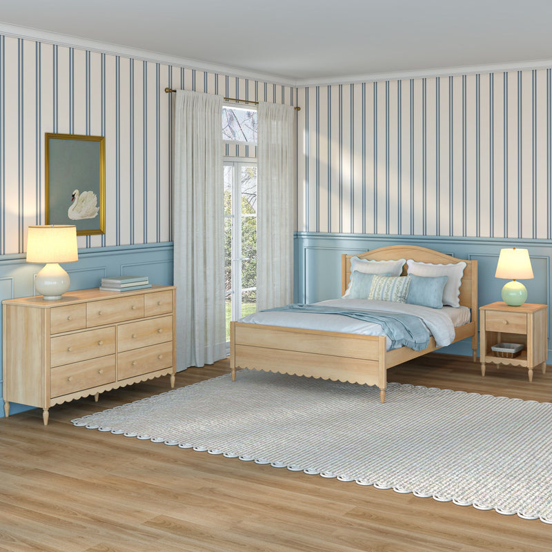 Coastal bedroom interior with blue striped wallpaper, light wood bed and dresser, pale blue wainscoting, sheer curtains over French doors, bedside lamps, swan artwork, braided rug and hardwood floor