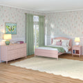 Pink girls bedroom with floral wallpaper, green curtains, pastel pink bed and dresser, butterfly wall art and bedside lamps — cozy kids' room decor