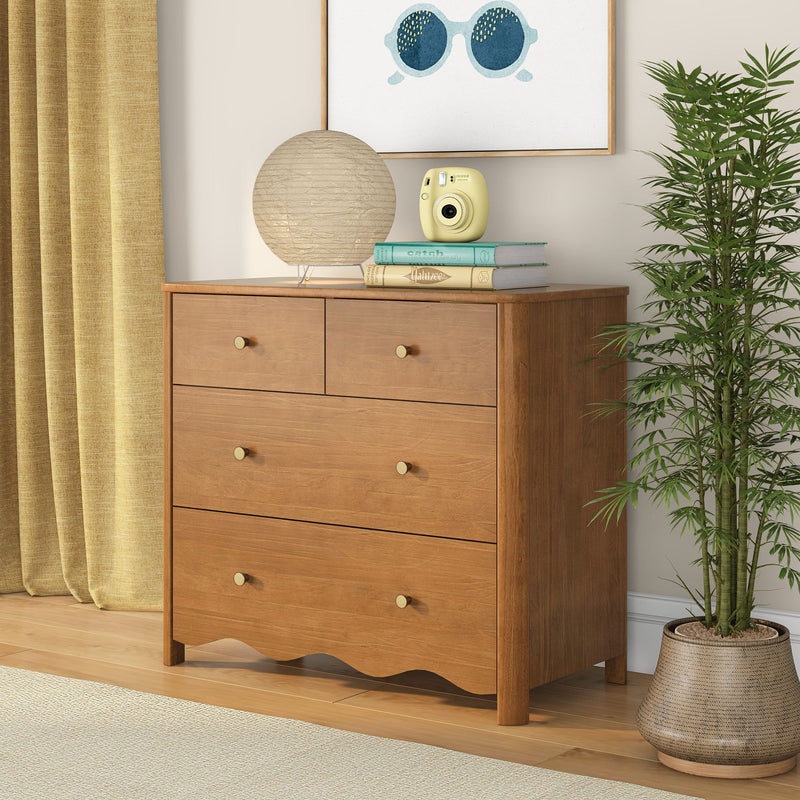 Mid-century modern oak dresser with brass knobs, paper lantern table lamp and yellow instant camera on stacked books, framed sunglasses art, potted bamboo and mustard curtains