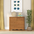 Wooden dresser in cozy home interior with framed sunglasses wall art, round paper lantern lamp, yellow instant camera, stacked books and potted plant