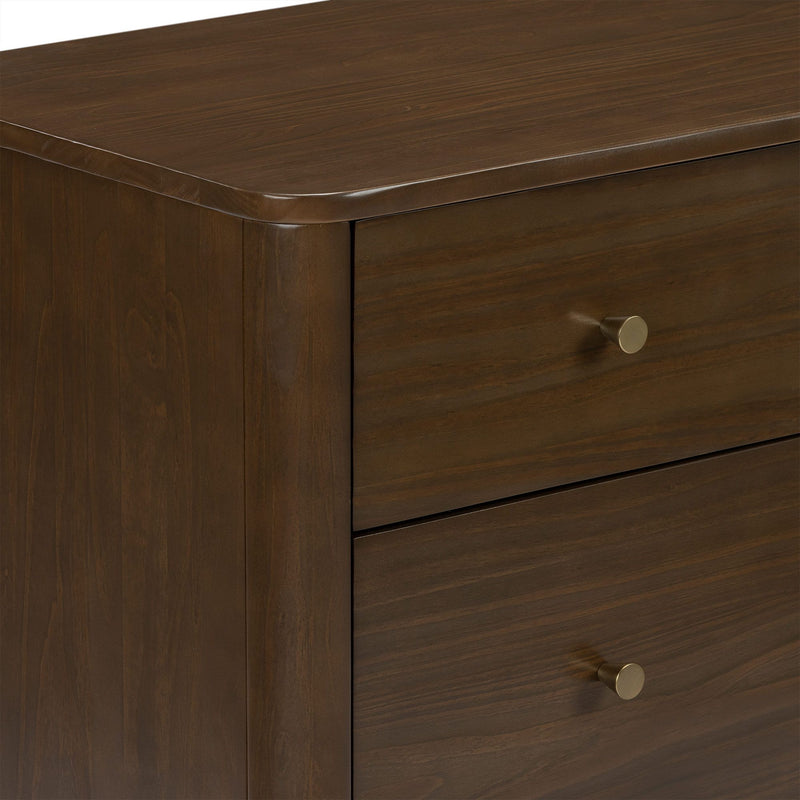 Close-up of dark brown wooden dresser drawer showing smooth rounded top edge, rich wood grain finish and brass round knob
