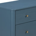 Close-up of a modern blue wooden dresser drawer corner with rounded top edge and gold metal knob, matte finish