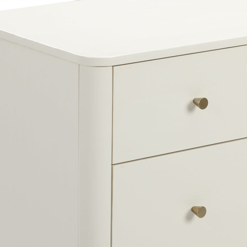 Close-up of modern white nightstand with rounded top edge, cream lacquer finish and brass drawer knob, minimalist bedroom dresser storage