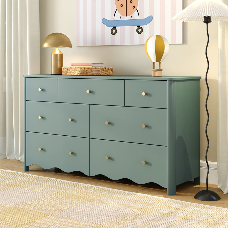 Mint green dresser with brass knobs in modern children's nursery, gold table lamp, woven basket, hot air balloon toy and skateboard wall art