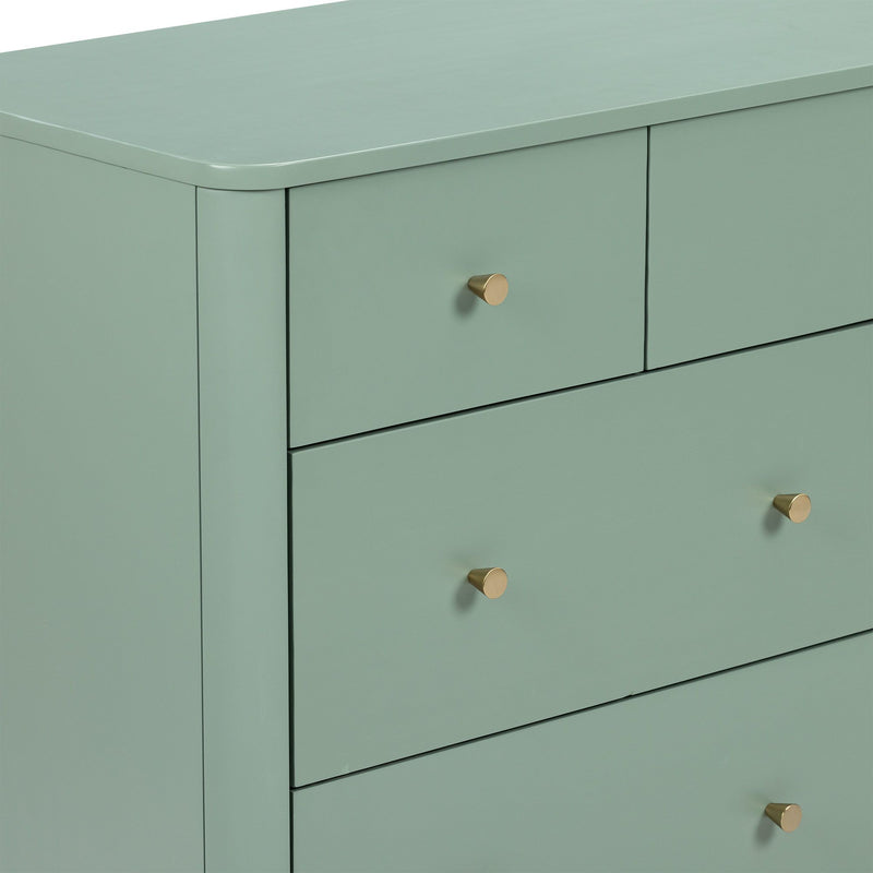 Close-up of matte sage green painted wooden dresser with brass cone drawer knobs, modern bedroom storage chest