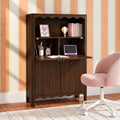 Dark wood secretary desk with hutch in a home office study nook, pink swivel chair, decorative lamp, books and tablet against peach striped wallpaper