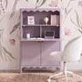 Pastel lavender kids desk cabinet with scalloped shelf, floral wallpaper backdrop, white boucle swivel chair and school supplies — girls' nursery study nook and storage solution