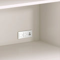 Modern white wall outlet with dual AC sockets and USB-A and USB-C ports installed above a beige kitchen countertop