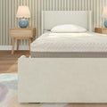 Minimal modern bedroom with cream upholstered bed frame and mattress, mid-century wooden nightstands, blue ceramic lamps and green striped wallpaper