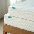 Two stacked 8-inch gel memory foam mattresses with white quilted cover on a wooden platform bed frame in a bright bedroom