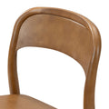 Wooden dining chair close-up showing curved backrest and seat in warm oak finish, mid-century modern solid wood design